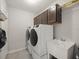 Functional laundry area with white washer, dryer, sink and overhead storage at 8199 Nordica Rd, Weeki Wachee, FL 34613