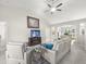 Bright living room with a ceiling fan, painting, TV, grey sofas and a turtle figurine on the side table at 8199 Nordica Rd, Weeki Wachee, FL 34613