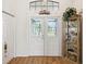 Foyer with decorative glass front doors, hardwood floors, and a glass display cabinet at 8401 Pavilion Dr, Hudson, FL 34667