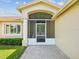 Home's inviting screened front porch, framed by manicured landscaping, with brick-paved entry at 8401 Pavilion Dr, Hudson, FL 34667