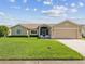 Charming single-story home featuring a well-manicured lawn and a two-car garage at 8401 Pavilion Dr, Hudson, FL 34667