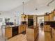 Open kitchen with wood cabinets, granite countertops, and an island overlooking the living room at 8401 Pavilion Dr, Hudson, FL 34667