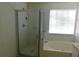 Bathroom features a glass-enclosed shower and tub, next to a bright window at 846 Burlwood St, Brandon, FL 33511