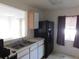 Functional kitchen with stainless steel sink, neutral countertops, wood cabinets, and black refrigerator at 846 Burlwood St, Brandon, FL 33511