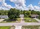 An aerial view of the home displays its roof, driveway, and yard with mature trees at 8979 Hernando Way, Weeki Wachee, FL 34613