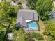Aerial view of a home featuring a screened-in pool area, nestled among trees, providing a private outdoor retreat at 8979 Hernando Way, Weeki Wachee, FL 34613