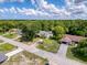 An aerial shot displaying a lovely home's roof, driveway, and lawn along a tranquil street at 8979 Hernando Way, Weeki Wachee, FL 34613
