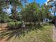 Landscaped backyard featuring garden beds, mature trees, and a storage shed offering a private outdoor space at 8979 Hernando Way, Weeki Wachee, FL 34613