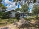 Backyard view of the screened-in pool area surrounded by lush landscaping and a stone pathway at 8979 Hernando Way, Weeki Wachee, FL 34613