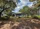 Wide shot of the back yard featuring the pool enclosure and landscaping at 8979 Hernando Way, Weeki Wachee, FL 34613