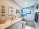 Bathroom featuring tiled floors, a vanity with marble countertop, and nautical themed decor at 8979 Hernando Way, Weeki Wachee, FL 34613