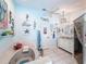 Bright bathroom featuring tiled floors, a tub, and whimsical coastal themed decor and vanity with double sinks at 8979 Hernando Way, Weeki Wachee, FL 34613