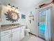 Bathroom featuring modern vanity with granite countertop, and outdoor access to the pool at 8979 Hernando Way, Weeki Wachee, FL 34613