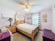 Bedroom featuring a four poster bed with luxurious bedding and purple decor at 8979 Hernando Way, Weeki Wachee, FL 34613