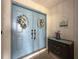 Inviting entryway featuring double blue doors adorned with wreaths and a decorative accent table at 8979 Hernando Way, Weeki Wachee, FL 34613