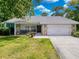 Charming single-story home with stone accents, a well-manicured lawn, and an attached two-car garage at 8979 Hernando Way, Weeki Wachee, FL 34613