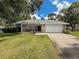 Beautiful home showcasing a well-kept lawn, stone details, and a two-car garage, perfect for Gathering living at 8979 Hernando Way, Weeki Wachee, FL 34613
