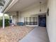 Inviting front porch with stone accents, seating area, and a charming blue front door with a wreath at 8979 Hernando Way, Weeki Wachee, FL 34613