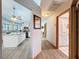 Hallway view of white kitchen with island and adjacent bathroom with white vanity and sink at 8979 Hernando Way, Weeki Wachee, FL 34613