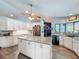 Open kitchen layout featuring granite countertops, a center island, stainless steel appliances, and hardwood floors at 8979 Hernando Way, Weeki Wachee, FL 34613