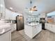Bright kitchen featuring granite countertops, a center island, stainless steel appliances, and hardwood floors at 8979 Hernando Way, Weeki Wachee, FL 34613