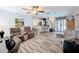 Open living room featuring hardwood floors, comfortable seating, and easy access to the kitchen and patio at 8979 Hernando Way, Weeki Wachee, FL 34613