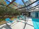 The screened enclosure hosts a pool, lounge chairs and dining set at 8979 Hernando Way, Weeki Wachee, FL 34613