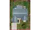 Overhead shot of the house and yard with view of the roof, surrounded by patchy grass and various items scattered around at 9134 Crabtree Ln, Port Richey, FL 34668