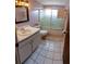 Bathroom featuring tile flooring, vanity, and framed mirror; perfect for a clean and functional space at 9134 Crabtree Ln, Port Richey, FL 34668