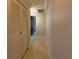 Hallway featuring tile flooring and leading to bedroom and bathroom; closets on the left at 9134 Crabtree Ln, Port Richey, FL 34668