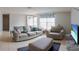 Comfortable living room featuring neutral colors, tile flooring, and lots of natural light from a large window at 9134 Crabtree Ln, Port Richey, FL 34668