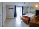 Bright main bedroom featuring tile flooring, ensuite bathroom, closet, and sliding glass door to the backyard at 9134 Crabtree Ln, Port Richey, FL 34668