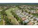 An aerial view showcases a residential community bordering a golf course, complete with lush trees and water features at 9149 Penelope Dr, Weeki Wachee, FL 34613