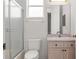 Cozy bathroom with glass shower doors, a light vanity, and neutral colored tile at 9149 Penelope Dr, Weeki Wachee, FL 34613