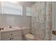 Bathroom with pastel-colored tiles, vanity, and a charming seashell-themed shower curtain at 9149 Penelope Dr, Weeki Wachee, FL 34613