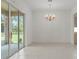 Dining room with tile flooring, chandelier, and glass sliding doors to the outside at 9149 Penelope Dr, Weeki Wachee, FL 34613