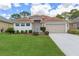 Inviting single-story home with a well-manicured lawn and a two-car garage at 9149 Penelope Dr, Weeki Wachee, FL 34613