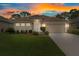 Charming single-story home with a well-manicured lawn and a two-car garage at sunset at 9149 Penelope Dr, Weeki Wachee, FL 34613