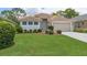 A well-manicured front lawn leads up to a cozy, single-story house with a two-car garage and neat landscaping at 9149 Penelope Dr, Weeki Wachee, FL 34613