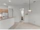 Kitchen view with white tile flooring and a breakfast bar, leading to adjacent room at 9149 Penelope Dr, Weeki Wachee, FL 34613