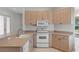 Kitchen featuring tile flooring, white appliances, and ample counter space at 9149 Penelope Dr, Weeki Wachee, FL 34613