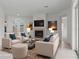 Staged living room with fireplace, sofas, artwork, and neutral tile flooring creates an inviting space at 9149 Penelope Dr, Weeki Wachee, FL 34613