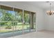 Living room with tile flooring, large glass sliding doors, and chandelier at 9149 Penelope Dr, Weeki Wachee, FL 34613