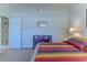 Bright bedroom with colorful quilt, bookshelf, and neutral carpet at 9406 Burnam Dr, Weeki Wachee, FL 34613