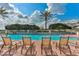Inviting community pool at GlenLakes with lounge chairs and palm trees at 9406 Burnam Dr, Weeki Wachee, FL 34613