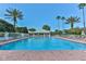 Large community pool with brick surround, lounge chairs, and lush landscaping at 9406 Burnam Dr, Weeki Wachee, FL 34613