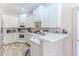 Modern kitchen with white cabinetry, countertops, and modern appliances at 9406 Burnam Dr, Weeki Wachee, FL 34613