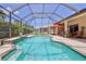 Sparkling screened-in pool with beautiful tile accents and an adjacent patio seating area at 9406 Burnam Dr, Weeki Wachee, FL 34613