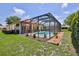 A screened-in pool area with a well-maintained pool, patio, and lush green lawn at 9406 Burnam Dr, Weeki Wachee, FL 34613