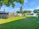 Spacious backyard featuring a well-maintained lawn, fence, and trees at 9425 Sterling Ln, Port Richey, FL 34668